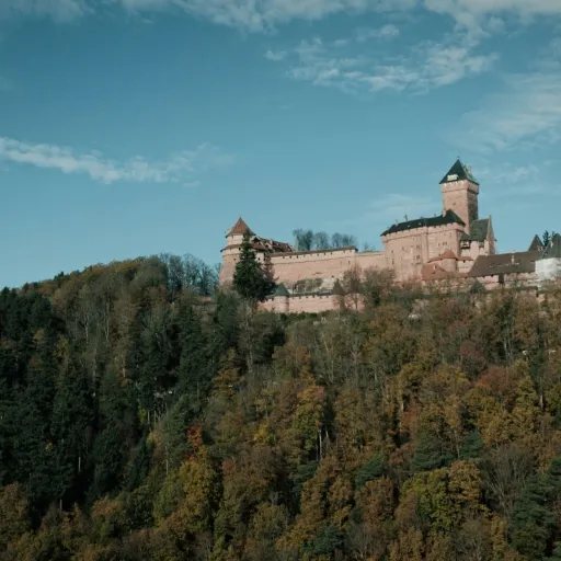 Le château du Haut-Koenigsbourg perché sur sa colline boisée, en automne