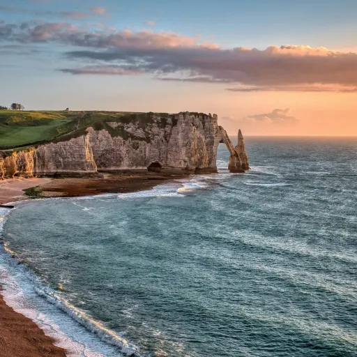 La plage de galets et la falaise d'Étretat dans la lumière du soir, pays de Caux