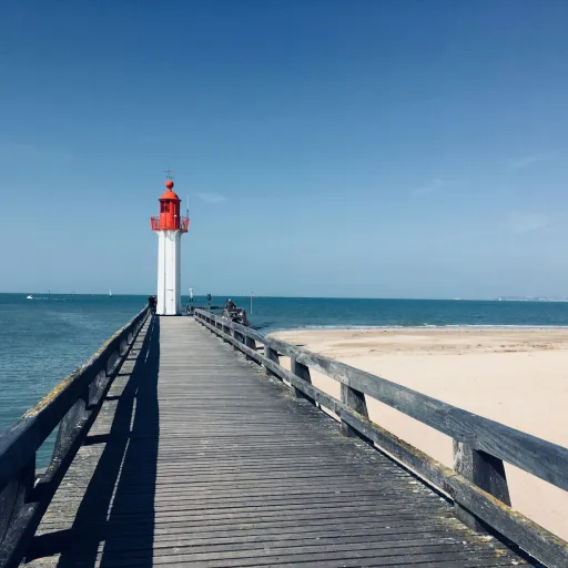 Jetée en bois et phare rouge et blanc à l'embouchure de la Touques, sur la Côte Fleurie